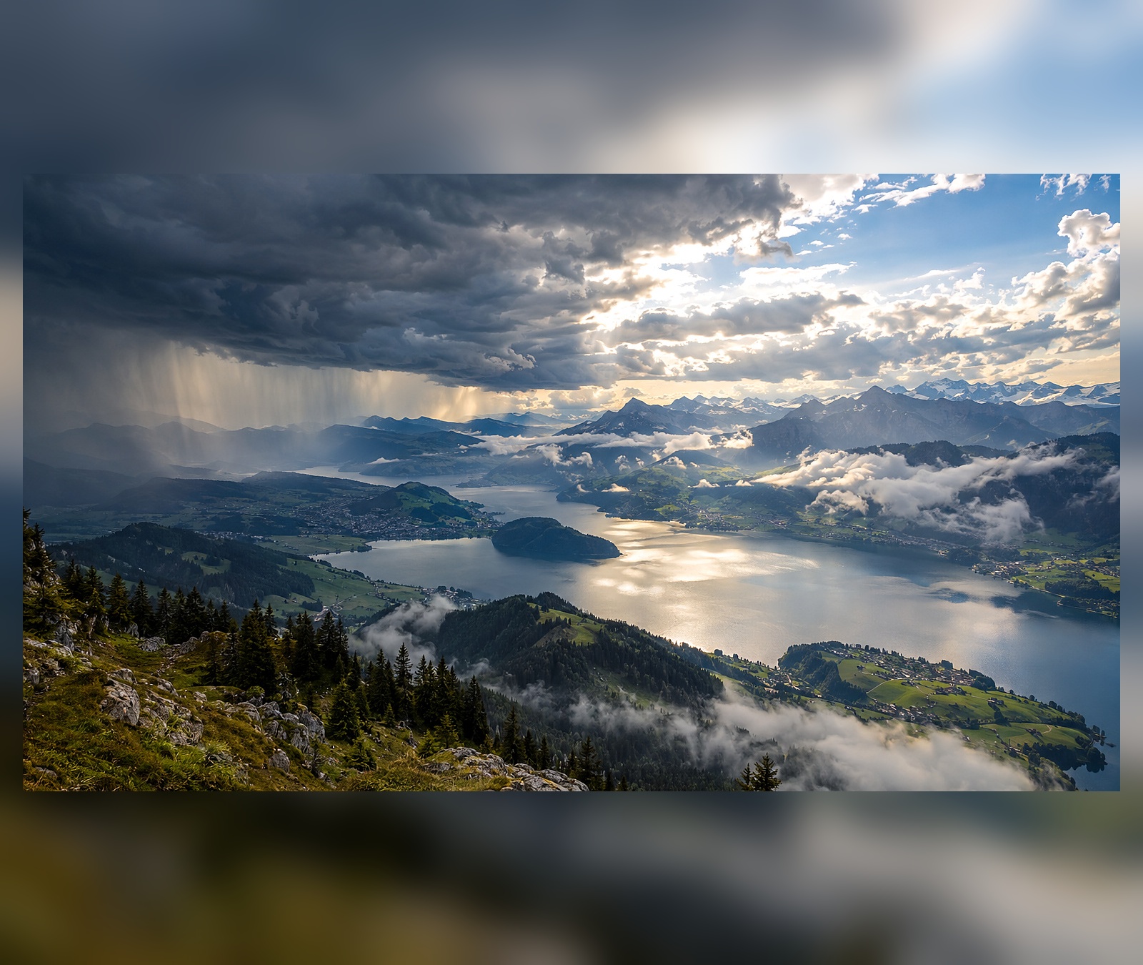 Kräftige Schauerfront mit Regenvorhängen über einer Berglandschaft