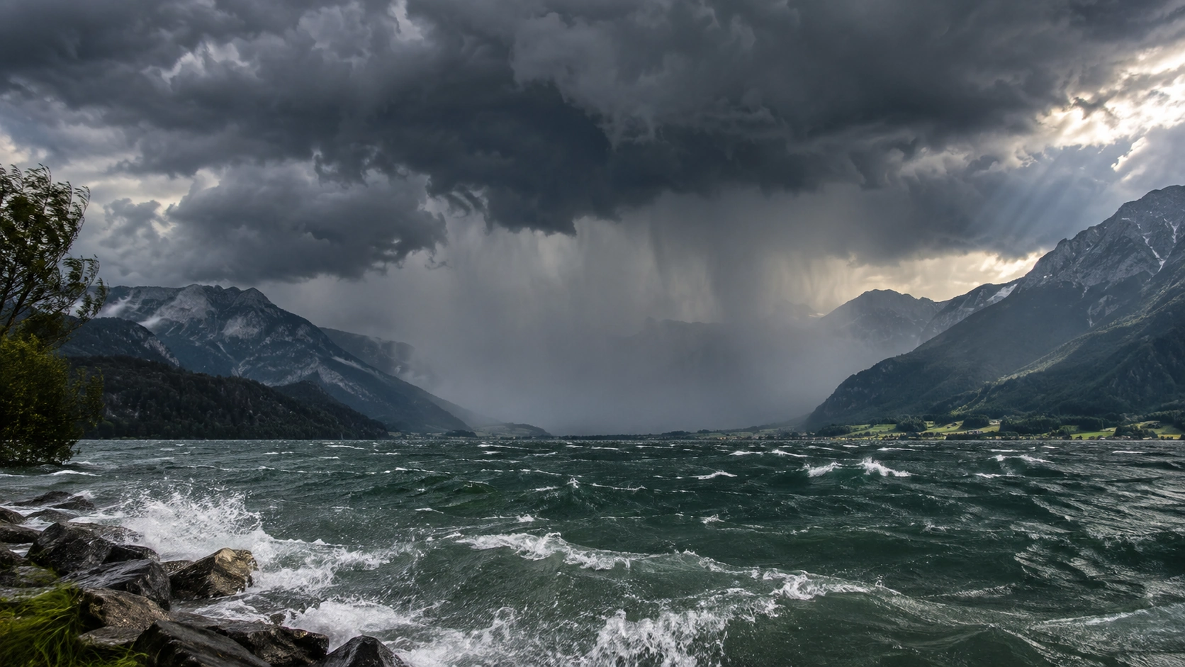 Aufgewühlter Alpensee unter dunklen Wolken als neutrales Symbolbild für Wind und lokale Wettergefahren auf Seen